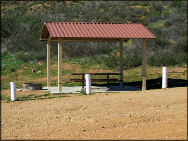Photo of shade gazebo on concrete pad with picnic table and fire ring.