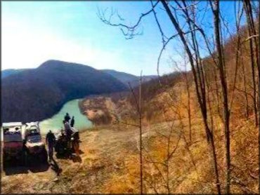 Scenic photo of two side by sides and one ATV parked with Potomac River in the back.