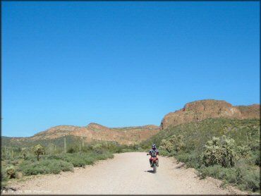 Honda dirt bike on wide graveled dirt road.