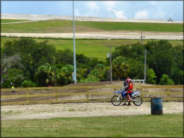 Man sitting on Yamaha dirt bike talking to friend.