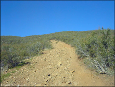 Wide but hard packed ATV trail with loose chunk rock.