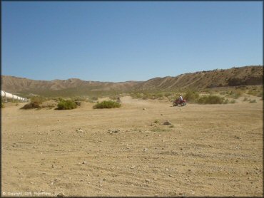 Two ATVs riding on desert trail near the Los Angeles Aqueduct pipeline.