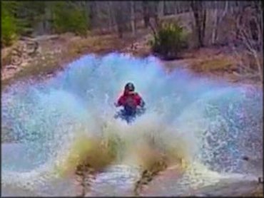 Yamaha ATV splashing through mud and water on the trail.