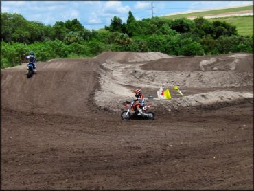 KTM and Yamaha mini dirt bikes on motocross track.