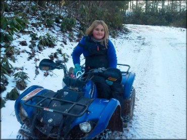 Young girl sitting on Yamaha Grizzly ATV with Moose Racing hand guards on handlebars.