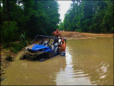 Yamaha Wolverine X4 Four Seat UTV stuck in deep water with two men in the back.