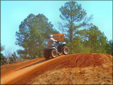 Man riding four wheeler on motocross track.