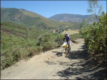 Suzuki RM-100 dirt bike on ATV trail.