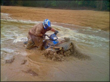 Polaris Sportsman navigating a deep mud pit.