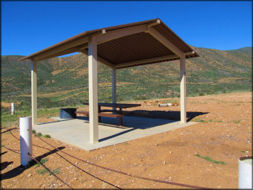 Photo of shade gazebo on concrete pad with picnic table and fire ring.