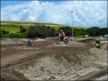 Man on Honda dirt bike getting a little air on motocross track.