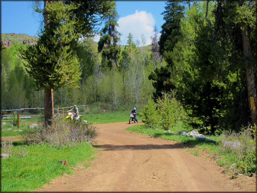 Father and son on dirt bikes heading into camp.