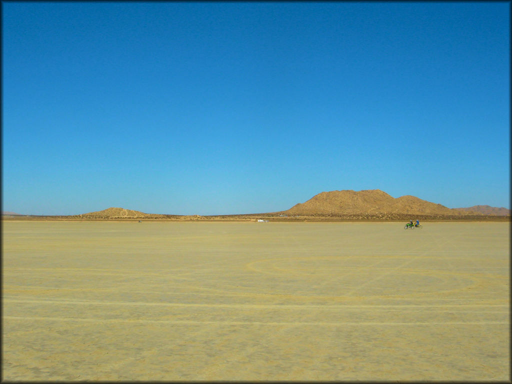 View of flat lakebed with two dirt bikes.