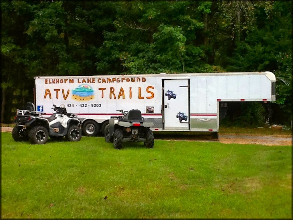 Horse trailer with campground name and phone number painted on side.