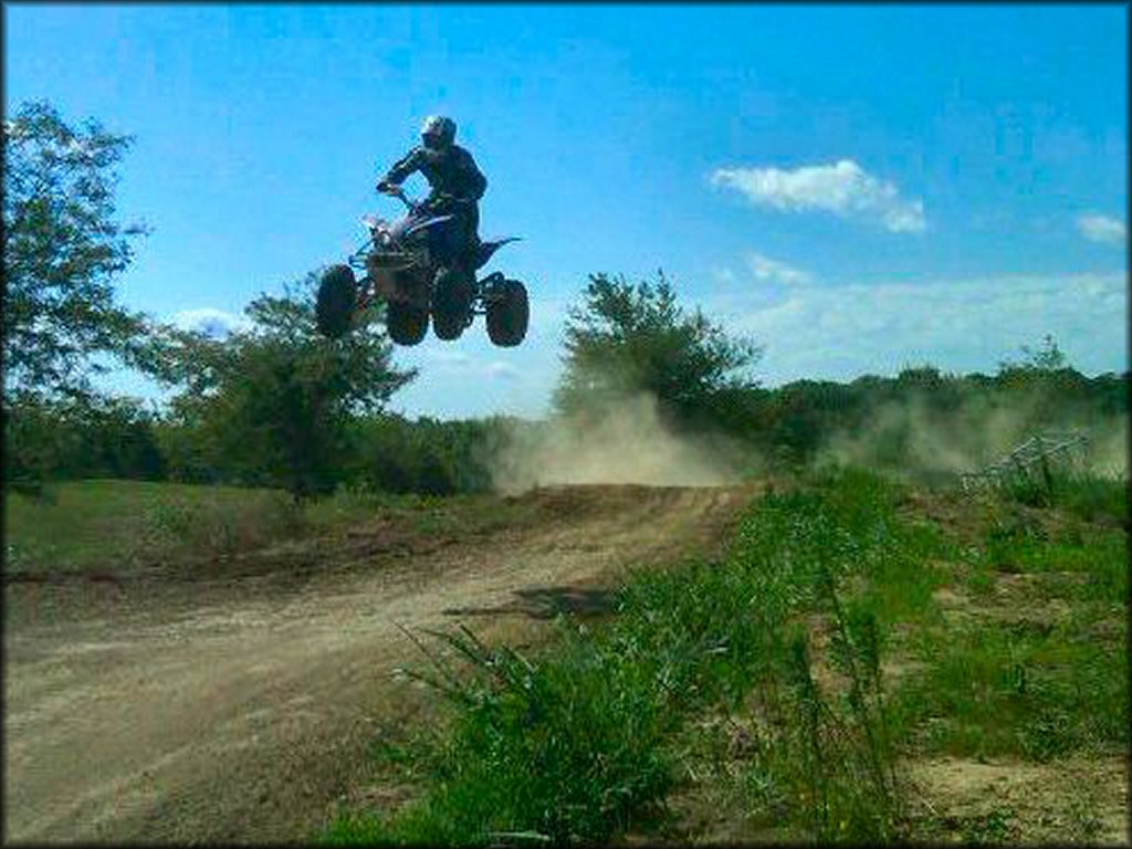 Yamaha Raptor jumping on motocross track.