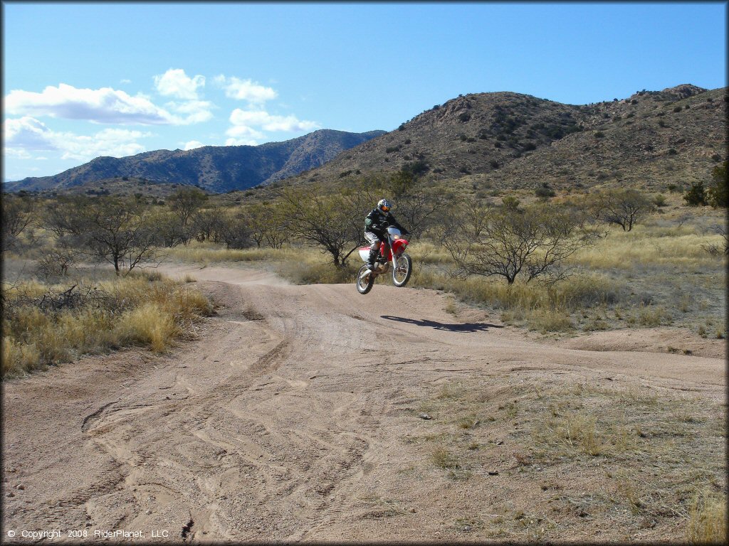 Honda CRF Motorcycle getting air at Redington Pass Trail