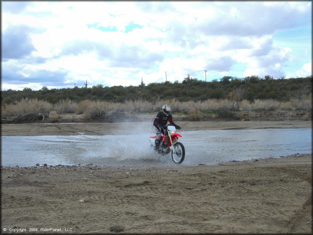 Honda CRF Dirt Bike crossing the water at Black Hills Box Canyon Trail