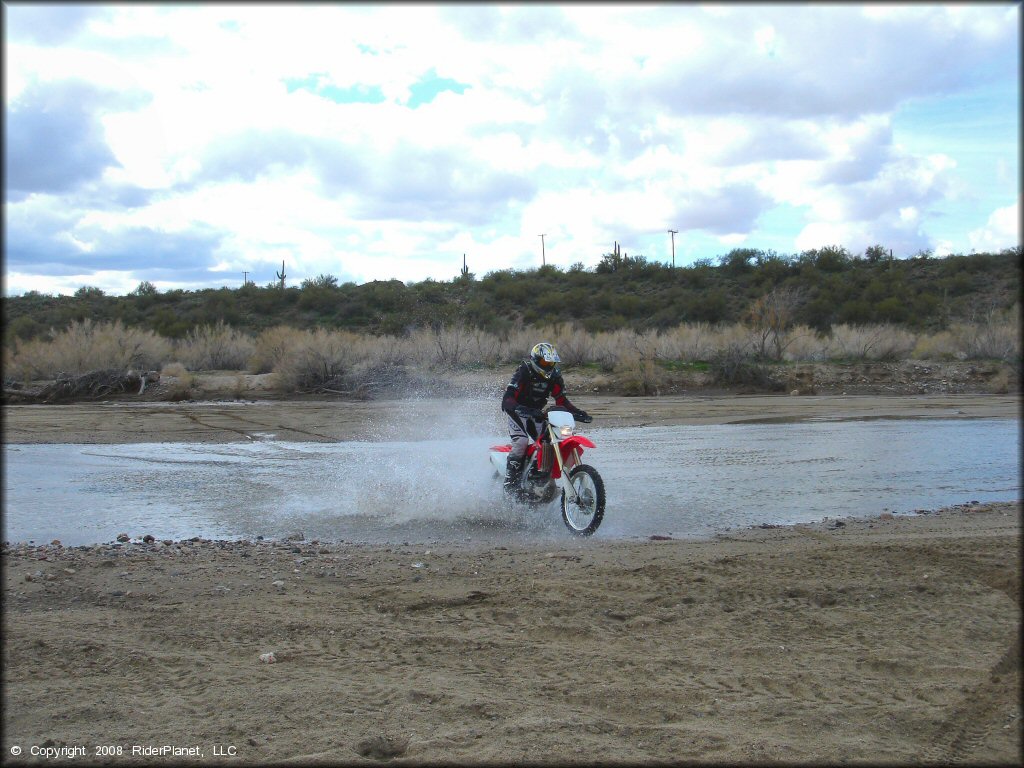 Honda CRF Dirt Bike crossing some water at Black Hills Box Canyon Trail