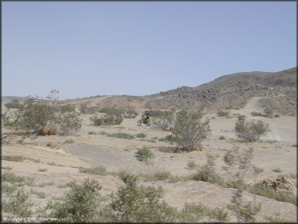 Suzuki dirt bike going through the desert.