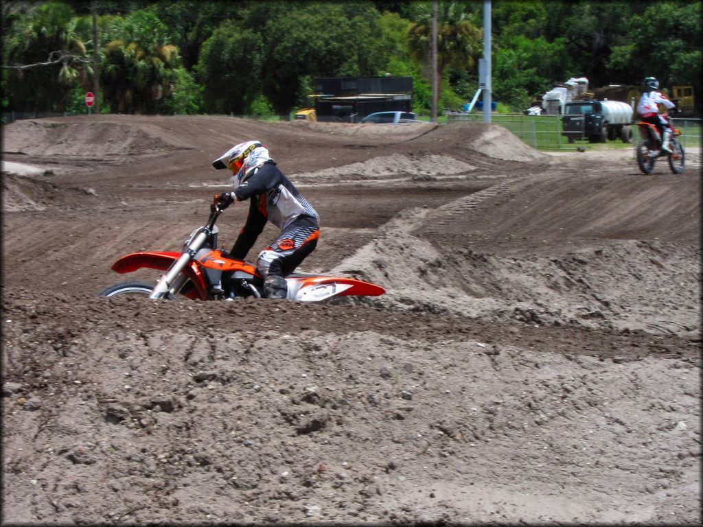 KTM dirt bike going through deep berm on motocross track.