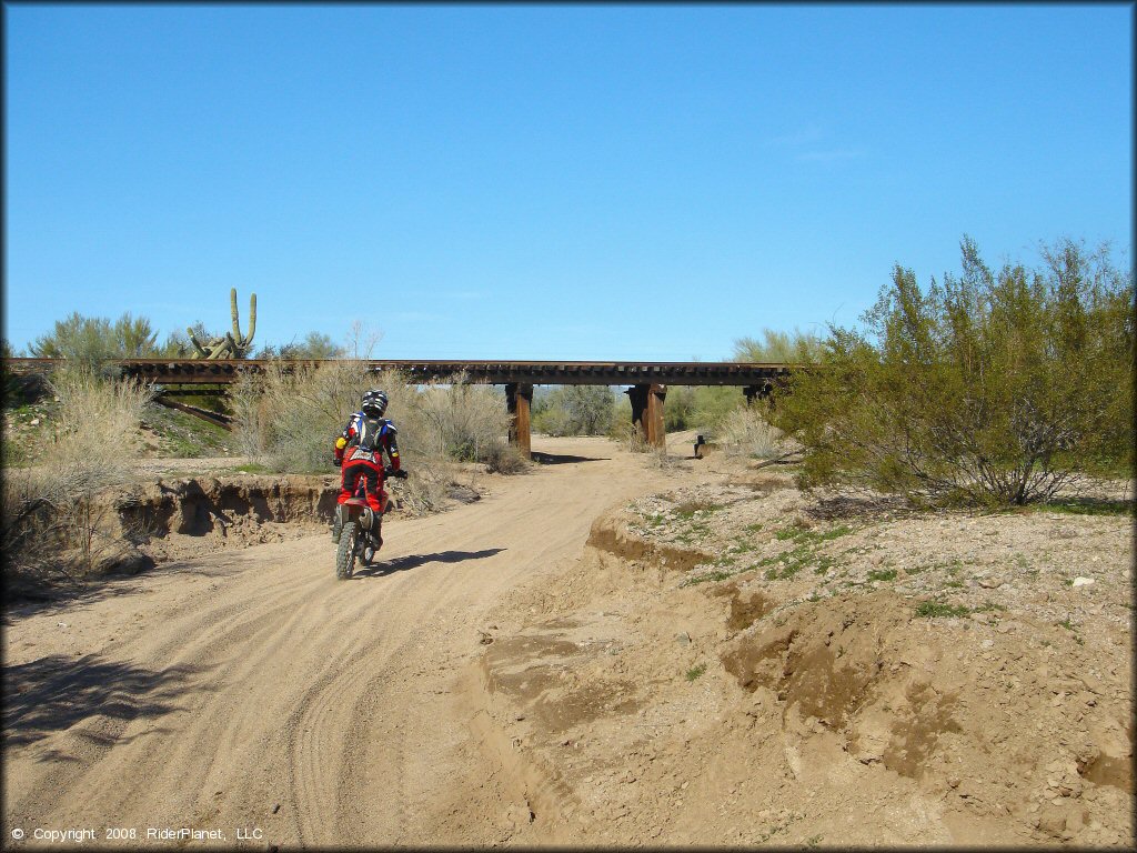 Honda CRF-150 dirt bike going through a sandy wash.