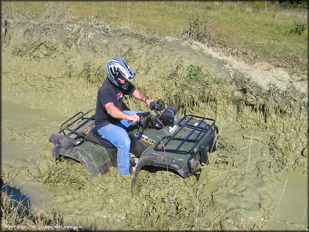 Honda ATV crossing the water at Big Rock Off Road Park Trail