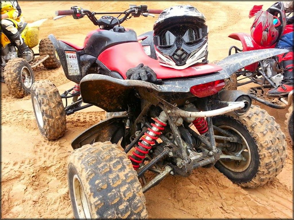 Honda ATV parked with helmet, goggles and gloves placed on the seat.