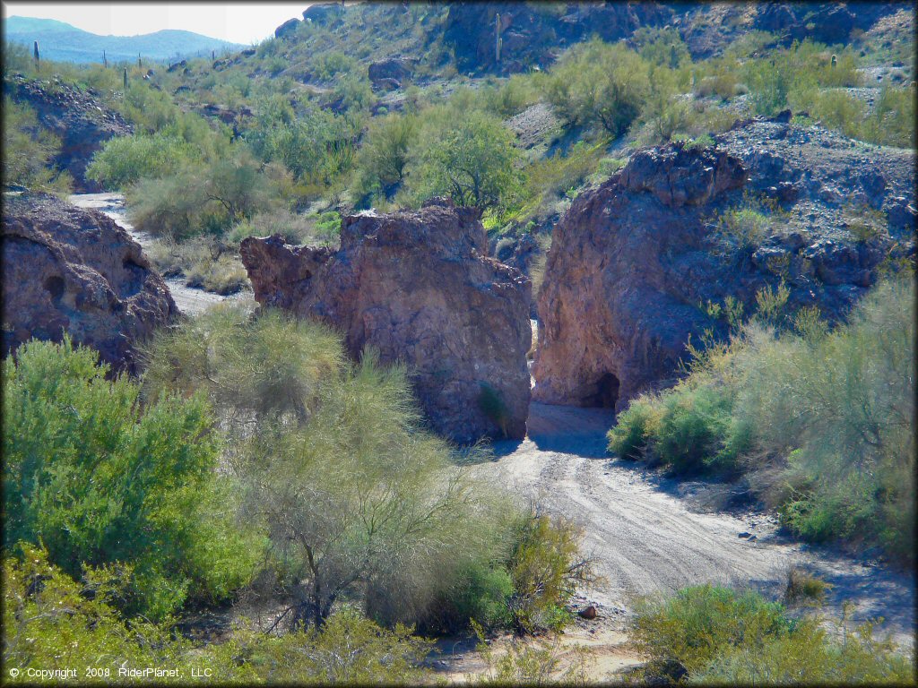 A top down view of large rock boulders with sand washes cutting through.