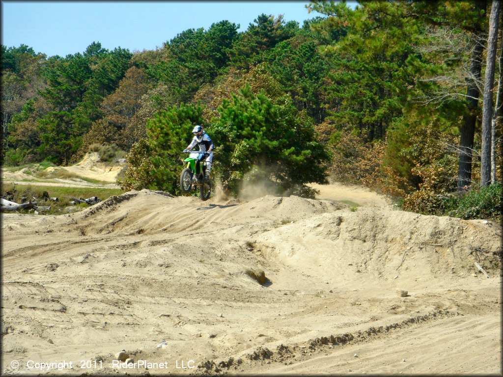 KX four-stroke dirt bike jumping on motocross track.