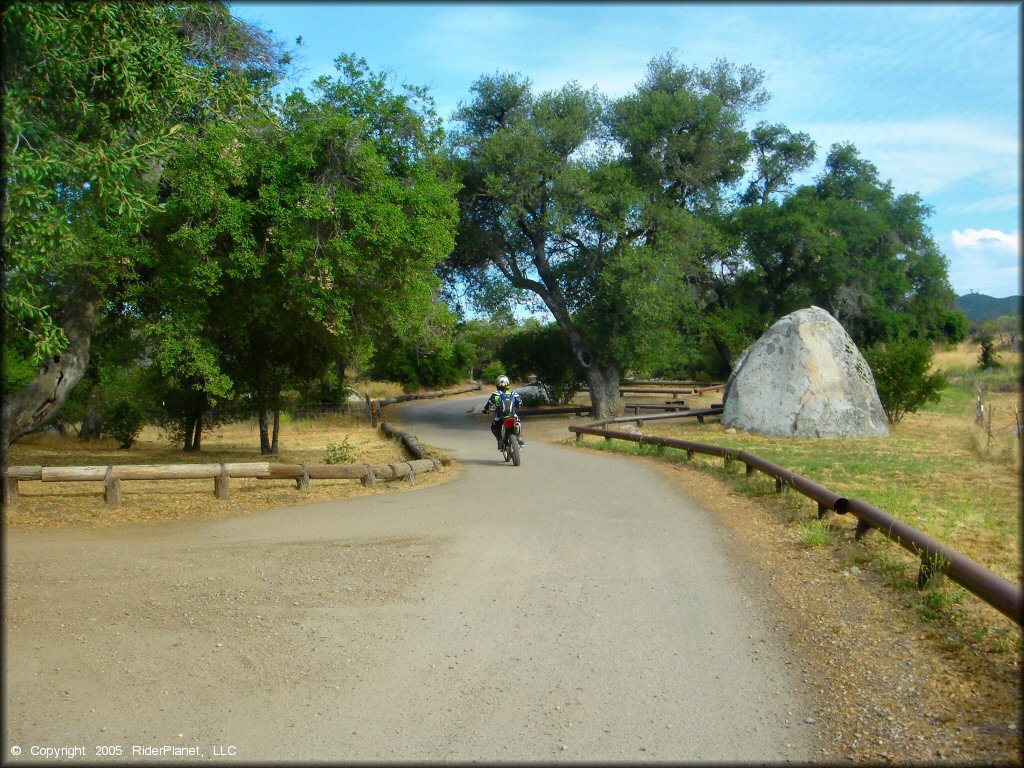 Rider on Honda dirt bike leaving campground.