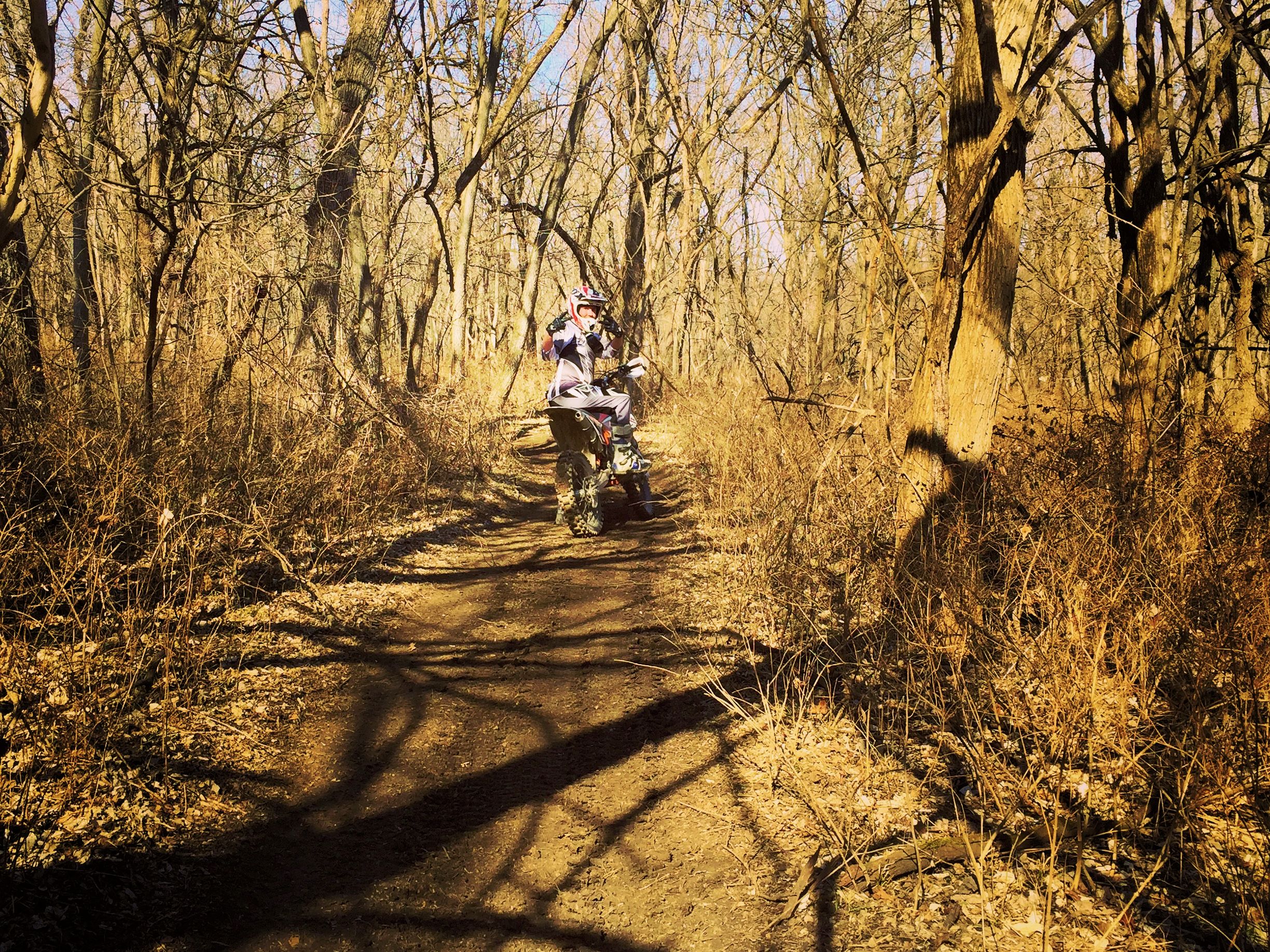 Dirt bike on ATV trail in the woods.