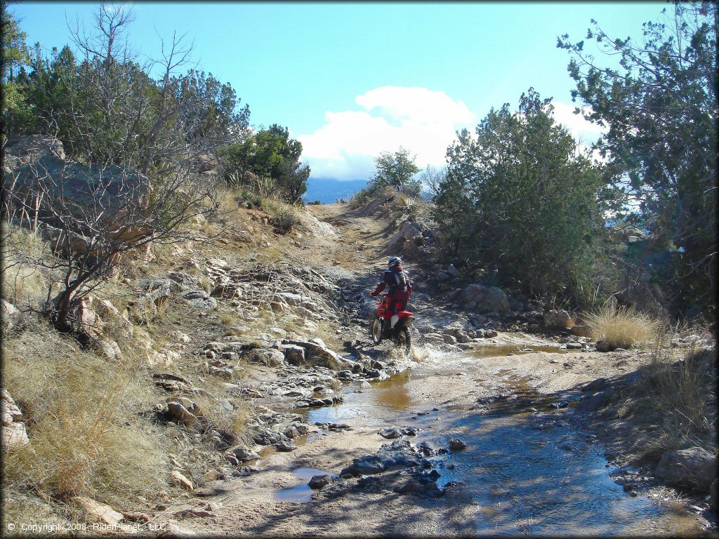 Honda CRF Motorcycle crossing some water at Redington Pass Trail