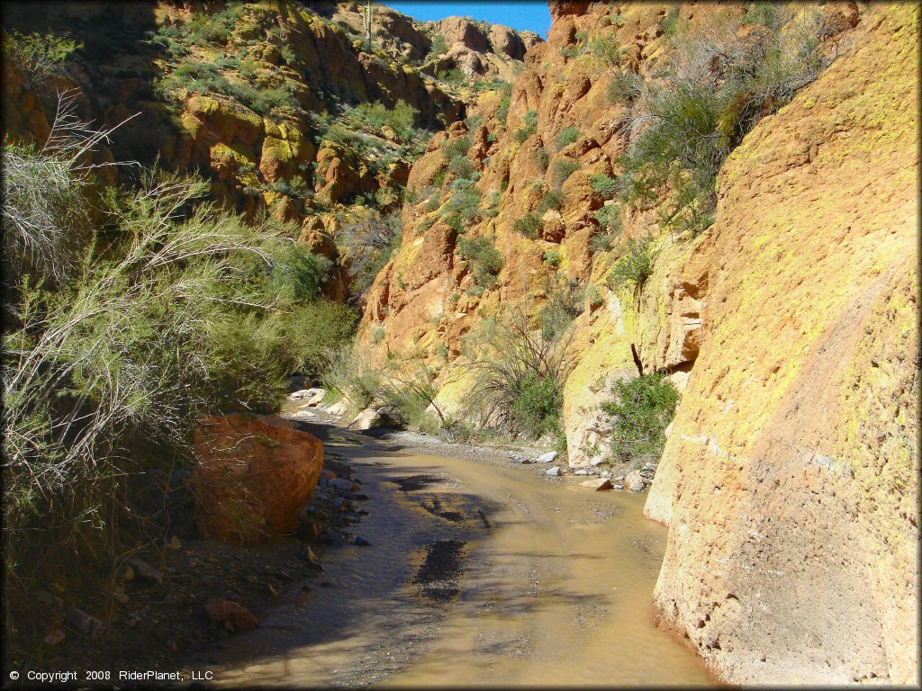 Scenic view of shallow stream going through colorful box canyon.