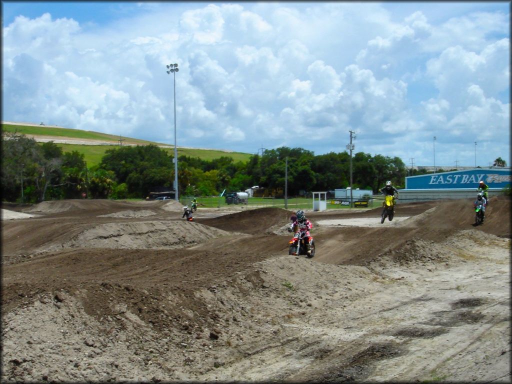 Honda, Suzuki and Kawasaki dirt bikes on motocross track.