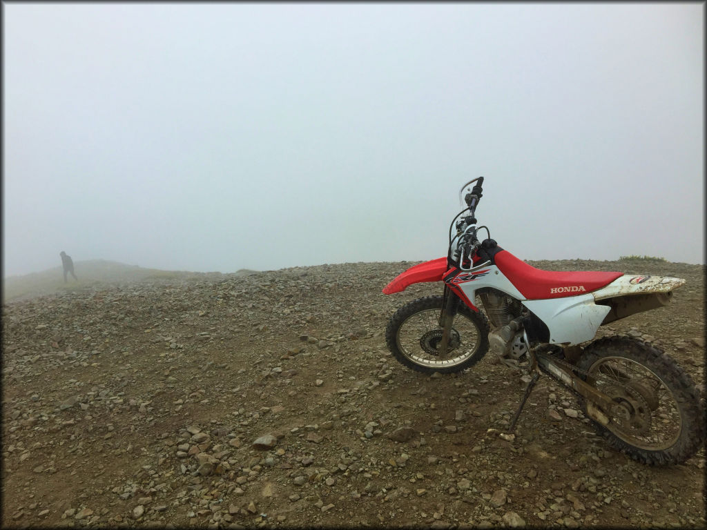 Honda CRF on the edge of rocky mountain peak.