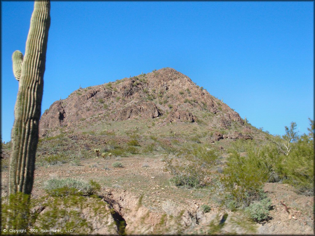 A scenic portion of the surrounding hills and cactuses.