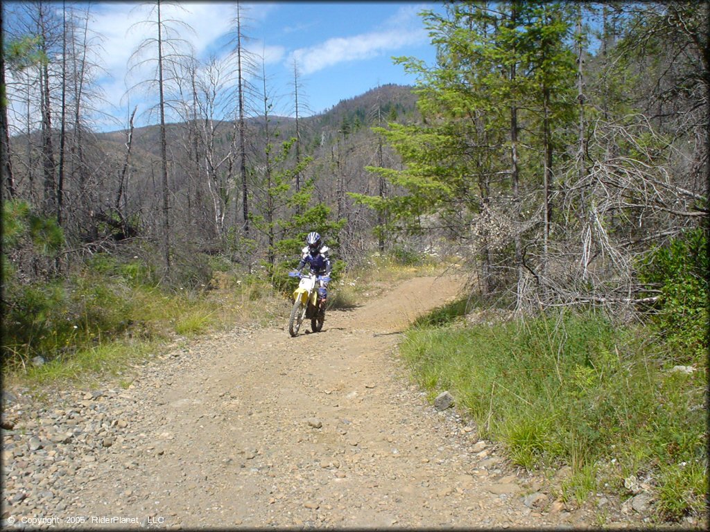 RM100 dirt bike on rocky 4x4 trail.