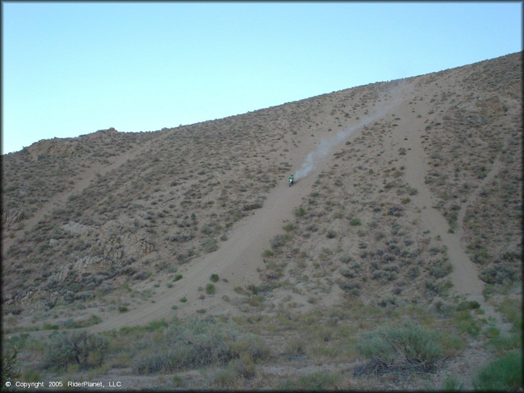 Kawasaki 500cc two-stroke coming down a steep and sandy hill climb.