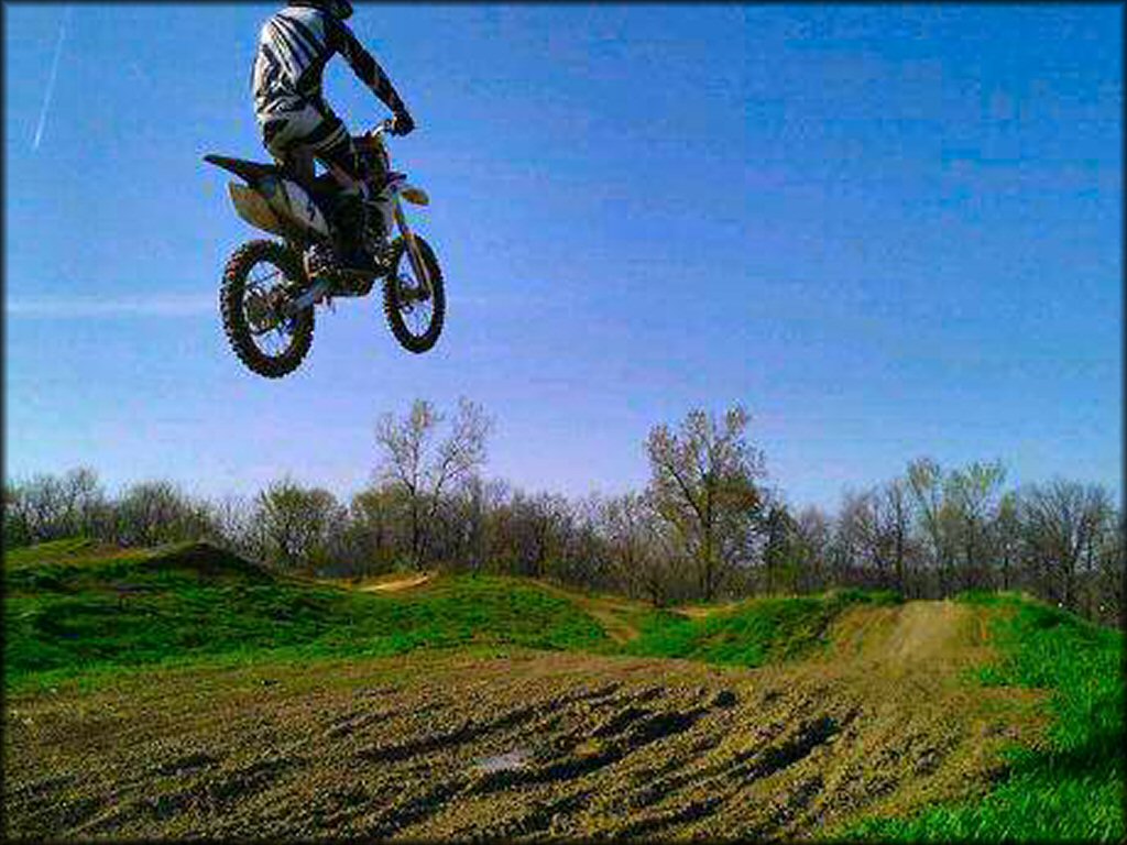 Yamaha dirt bike getting big air on a motocross track.