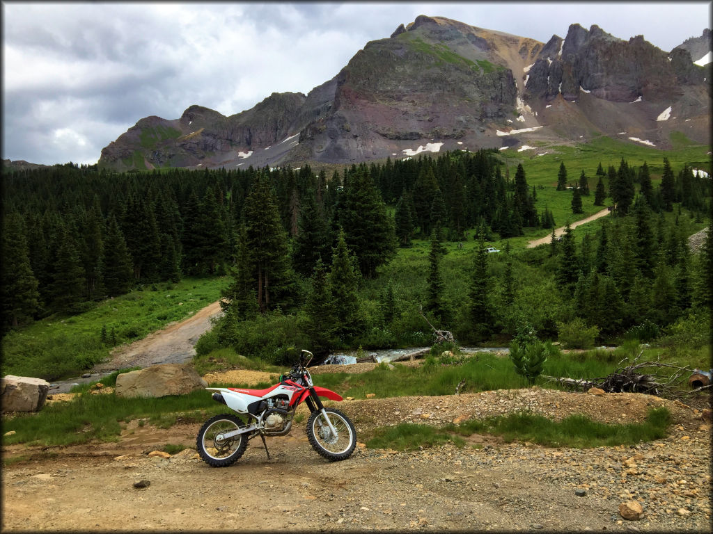 A Honda CRF 230cc motorcycle on the trail on a rocky mountain pass.